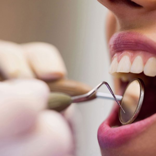 dentista-examinando-una-paciente-con-herramientas